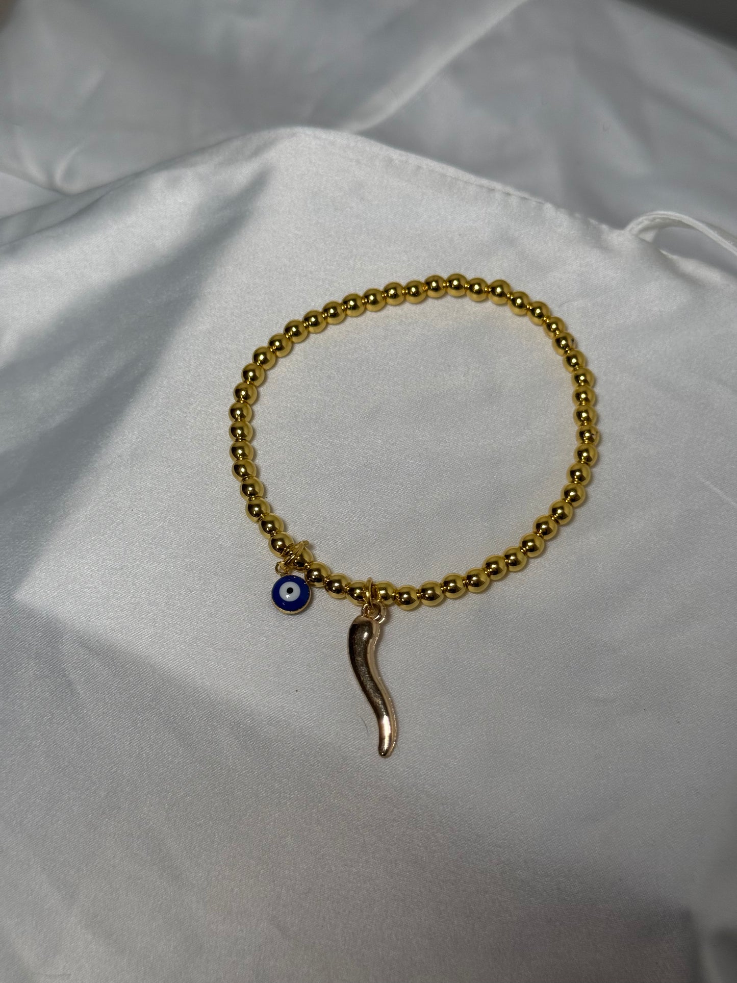 Gold beaded evil eye, and horn bracelet