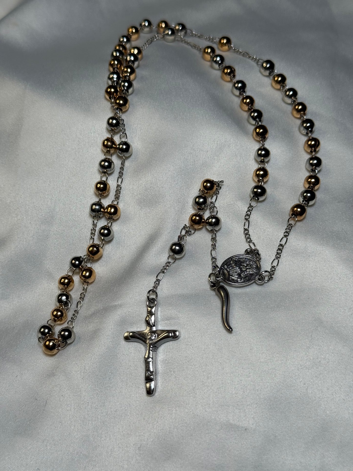 Gold and silver colored rosary bead featuring the Italian horn