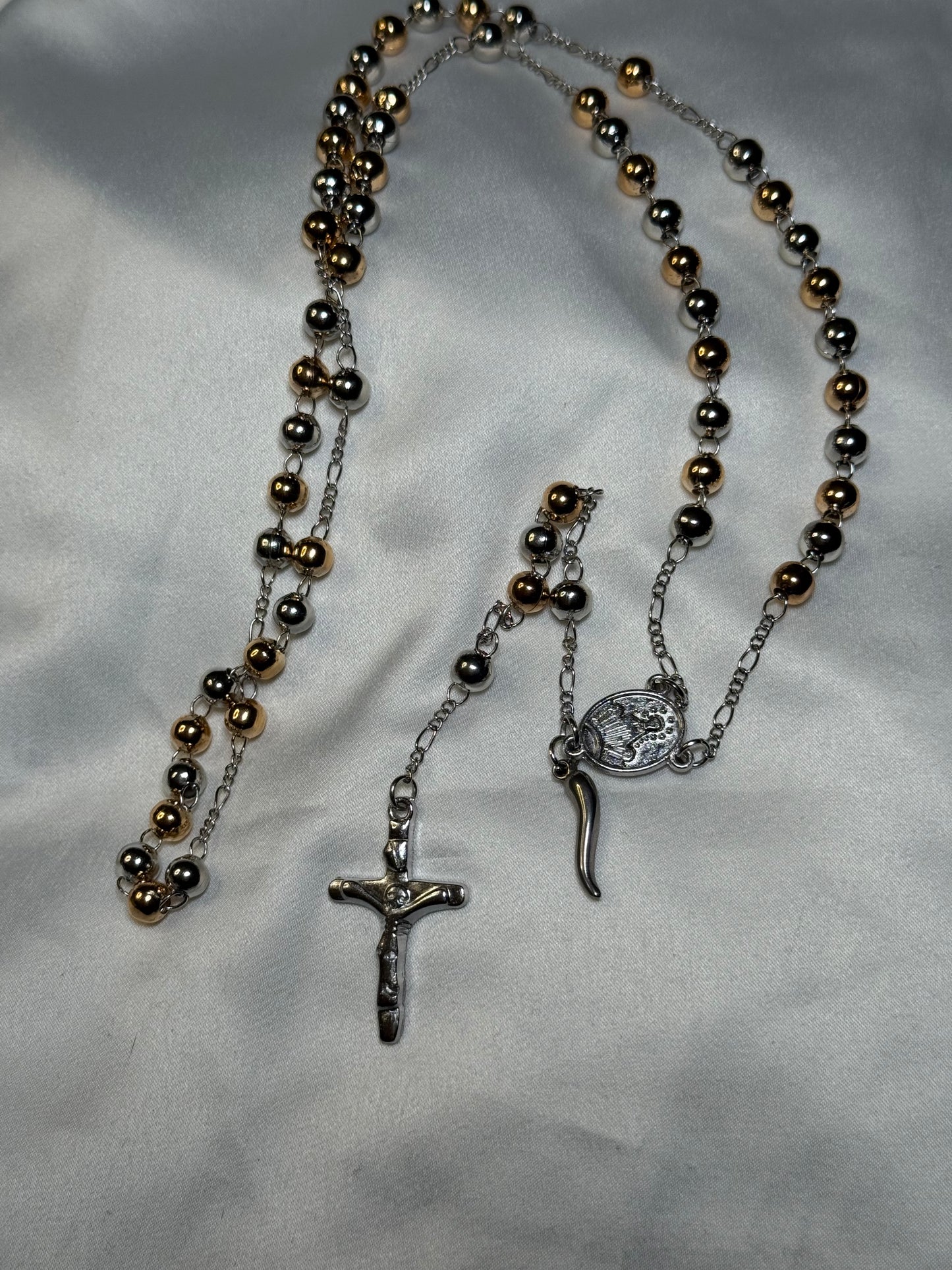 Gold and silver colored rosary bead featuring the Italian horn