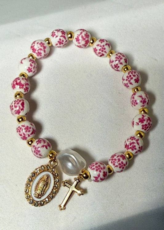 Pink and white ceramic beaded bracelet with gold colored blessed mother and cross