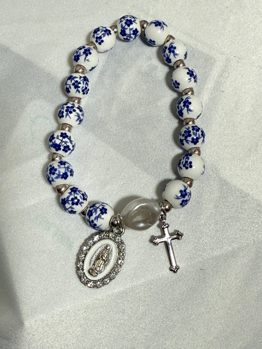 Blue and white beaded bracelet with the blessed mother and cross in silver color